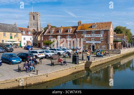 The Quay in Wareham, einer attraktiven Marktstadt in Dorset, England, Großbritannien. An einem sonnigen Herbsttag am Fluss Frome entspannen sich die Leute draußen Stockfoto