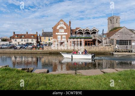 The Quay in Wareham, einer attraktiven Marktstadt in Dorset, England, Großbritannien. An einem sonnigen Herbsttag am Fluss Frome entspannen sich die Leute draußen Stockfoto