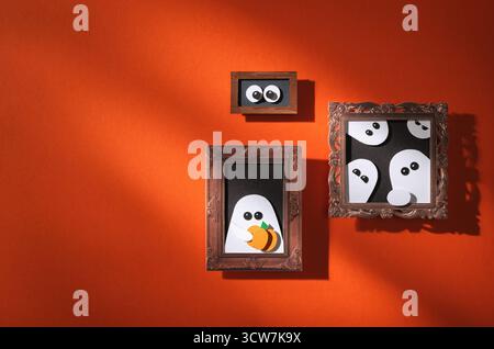 Handgefertigtes Papier für Halloween. Rote Wand mit Porträts von Geistern und Kürbissen. Platz für Ihren Text. Stockfoto
