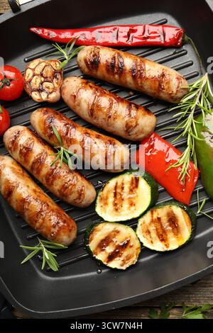 Pfanne mit gegrillten Würstchen, Gemüse und Gewürzen, Blick von oben Stockfoto