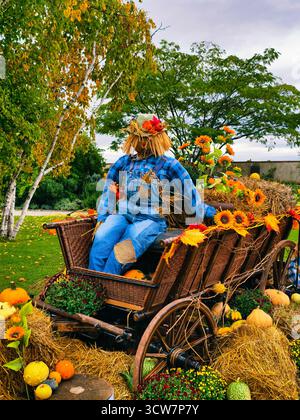 Herbst Vogelscheuche auf Holzwagen mit Kürbissen Sonnenblumen Hay Herbst Garten Dekoration Ernte Festival Display Thanksgiving Szene. Herbst Hintergrund Stockfoto