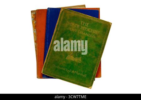 Auswahl an alten Hardcover-Büchern im Vintage-Alter mit dem Imp of Mischief-Buch von Olive Chandler oben isoliert auf weißem Hintergrund Stockfoto