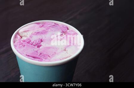 Köstliches Blaubeeren-Joghurt-Eis in einer großen Tasse auf Holztisch Stockfoto