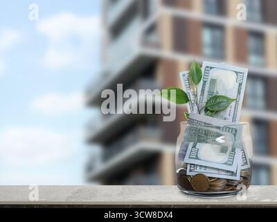 Glas mit Dollars und Münzen gegen Eigentumswohnung. Geld sparen, um eine Wohnung zu kaufen Stockfoto