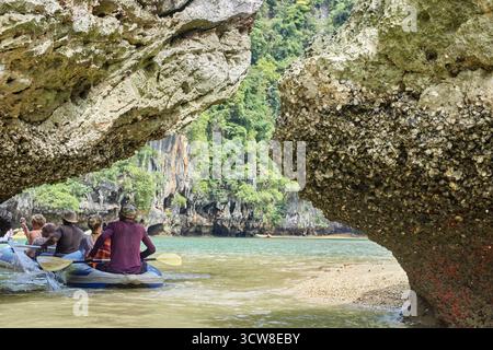 PHUKET, THAILAND - 12. NOVEMBER 2017: Kajakabenteuer in Gruppen durch malerische Kalksteinhöhlen und üppige Wälder in tropischer Küstenlandschaft. Stockfoto