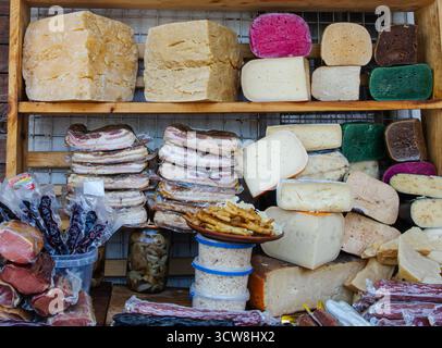Gemischter geräucherter Speck und farbenfrohe Käsesorten auf dem traditionellen ukrainischen Bauernmarkt. Natürliche, selbstgemachte Bio-Lebensmittel von lokalen Bauern. Stockfoto