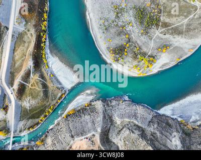 Gerade nach unten, das pulsierende türkisfarbene Wasser des Katun River, das auf einen Nebenfluss trifft, mit felsigen Ufern und Herbstlaub Stockfoto