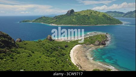 Fidschi, Kuata Insel: Atemberaubende tropische Inseln aus der Vogelperspektive mit üppiger grüner Vegetation, umgeben von kristallklarem türkisfarbenem Wasser. Berge, weißer Sandstrand, Korallenriffbucht. Drohnenflug Stockfoto