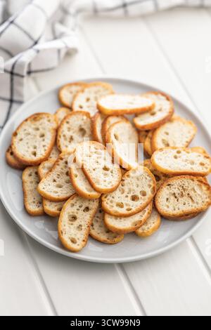 Knusprig geröstetes Bruschetta-Brot auf einem Teller auf einem weißen Tisch. Stockfoto