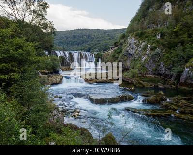 Štrbački buk Wasserfall am Fluss Una, Una Nationalpark, Bihać, Bosnien und Herzegowina - dramatische Travertinkaskade und smaragdgrüne Gewässer. Stockfoto