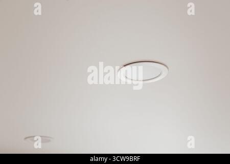 Weiße Stretchdecke mit Spots im Zimmer Stockfoto