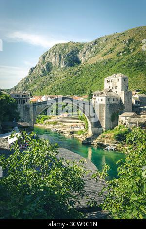 Stari Most (Alte Brücke) über den Neretva Fluss in Mostar, Bosnien und Herzegowina – historischer osmanischer Steinbogen, der sich in türkisfarbenem Wasser spiegelt. Stockfoto