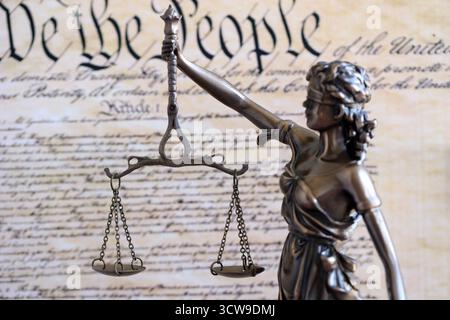 Die Statue der Gerechtigkeit Themis, die Göttin der Gerechtigkeit mit den Augen gegen die US-Verfassung Seite. Urteil und Strafe in den Vereinigten Staaten Stockfoto