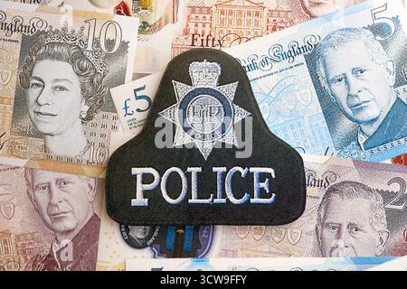 KIEW, UKRAINE - 17. SEPTEMBER 2025 Polizeiabzeichen des Vereinigten Königreichs auf britischen Pfund-Geldrechnungen Nahaufnahme Stockfoto