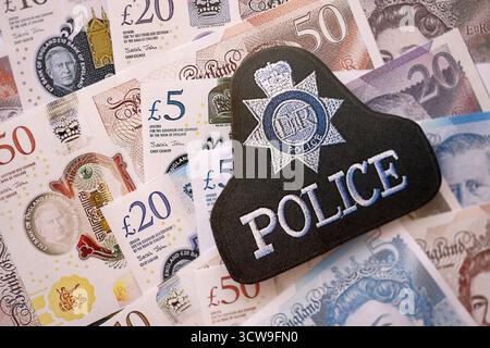 KIEW, UKRAINE - 17. SEPTEMBER 2025 Polizeiabzeichen des Vereinigten Königreichs auf britischen Pfund-Geldrechnungen Nahaufnahme Stockfoto