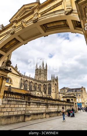 Bath, Vereinigtes Königreich - 25. April 2025 - Bath Abbey Towers Durch Den Reich Verzierten Roman Baths Arch Im Historischen Bath Mit Touristen, Die In Der City Cent Spazieren Gehen Stockfoto