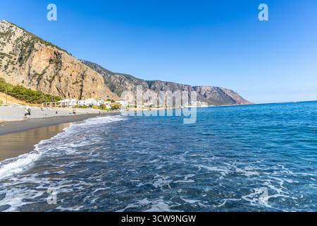 Kreta, Griechenland - 18. Oktober 2024: Strand von Agia Roumeli am Fuße der Samaria-Schlucht im Süden Kretas mit Fähren vor der Küste und Wanderern, die die genießen Stockfoto