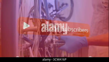 Mechaniker mit Handschuhen einstellen Radnabe in der Werkstatt mit Kettenradschlüssel überlagern Stockfoto