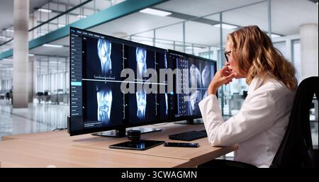 Weibliche Ärztin untersucht Knie-Röntgen auf Computer-Monitor-Bildschirm Stockfoto