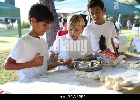Rom, Italien. Oktober 2025. Die Schüler machen Jiaozi, oder chinesische Knödel, während eines halbherbstlichen Jahrmarkts an der Marymount International School in Rom, Italien, am 10. Oktober 2025. Der Jahrmarkt fand hier am Freitag statt, wo Studenten und Anwohner eine Vielzahl chinesischer kultureller Aktivitäten und Vorstellungen von lokalen Enthusiasten der chinesischen Kultur genossen. Quelle: Li Jing/Xinhua/Alamy Live News Stockfoto