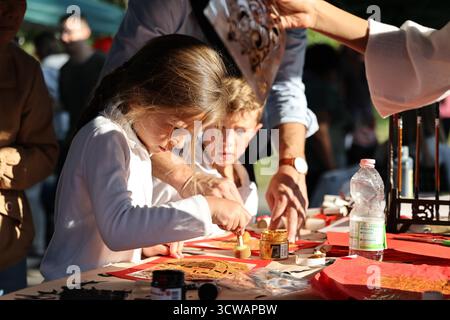 Rom, Italien. Oktober 2025. Ein Schüler reibt sich während eines Jahrmarkts zum Thema „Mitte-Herbst“ an der Marymount International School in Rom, Italien, am 10. Oktober 2025. Der Jahrmarkt fand hier am Freitag statt, wo Studenten und Anwohner eine Vielzahl chinesischer kultureller Aktivitäten und Vorstellungen von lokalen Enthusiasten der chinesischen Kultur genossen. Quelle: Li Jing/Xinhua/Alamy Live News Stockfoto