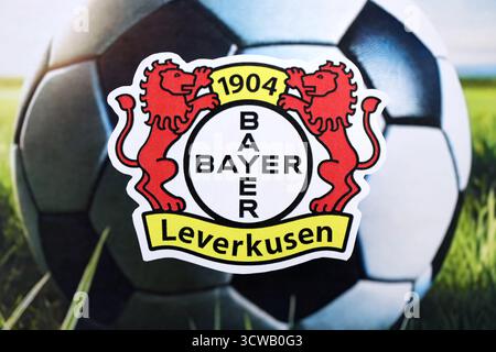 KIEW, UKRAINE - 23. FEBRUAR 2025 Bayer 04 Leverkusen Fußballklub-Abzeichen liegt auf einem Fußball-Hintergrund-Banner Stockfoto