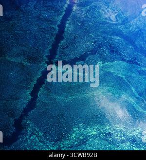 Abstrakte Wassertextur mit fließendem Dunkelblau und hellem Türkis mit schimmernden Mustern, die ein faszinierendes Bild der Natur erzeugen Stockfoto