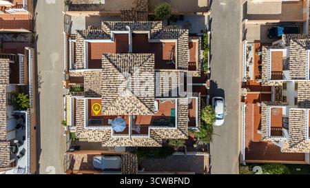 Luftbild von oben zeigt eine Villa im mediterranen Stil mit detailliertem Fliesendach, geräumiger Terrasse, Sonnenkollektor, Sonnenschirm und einem hervorgehobenen Haus Stockfoto