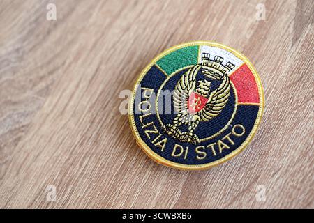 KIEW, UKRAINE - 6. SEPTEMBER 2025 Flicken der italienischen Staatspolizei auf brauner hölzerner Tischoberfläche Nahaufnahme Stockfoto