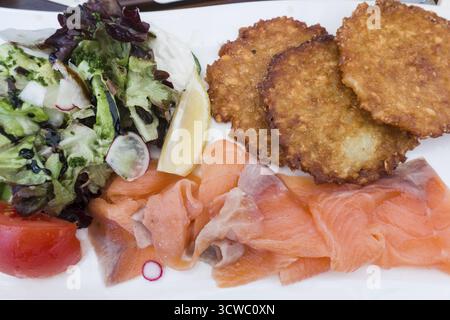 Kartoffelpfannkuchen mit Lachs und Salat Stockfoto