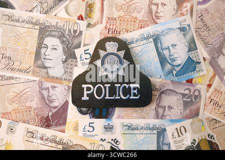 KIEW, UKRAINE - 17. SEPTEMBER 2025 Polizeiabzeichen des Vereinigten Königreichs auf britischen Pfund-Geldrechnungen Nahaufnahme Stockfoto