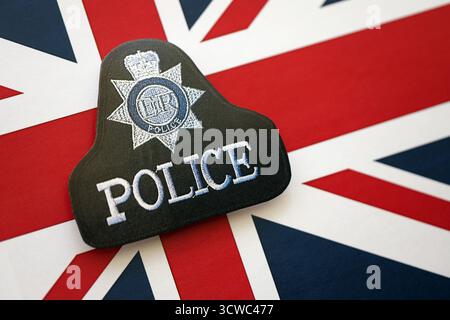 KIEW, UKRAINE - 17. SEPTEMBER 2025 Polizeiabzeichen des Vereinigten Königreichs auf der Flagge der British Union Jack Nahaufnahme Stockfoto