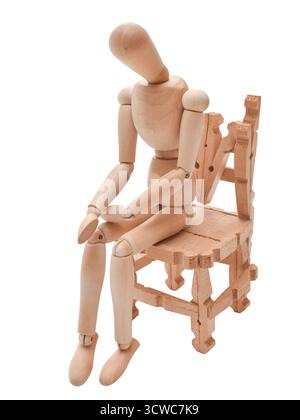 Die Figur aus Holz sitzt auf einem kleinen Stuhl und präsentiert eine kontemplative Haltung, die künstlerisches Design und handwerkliches Geschick in einem einfachen, na hervorhebt Stockfoto