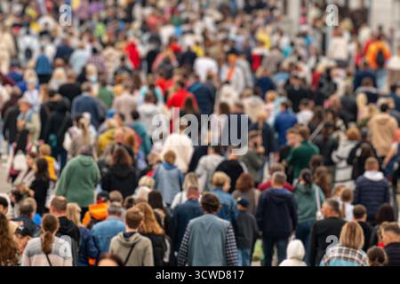 Nicht erkennbare Masse von Menschen, die in der Stadt spazieren gehen. Hintergrund einer verschwommenen Menschenmenge in der Stadt während der Hauptverkehrszeit am Nachmittag. Die Unschärfe ist effektiv Stockfoto