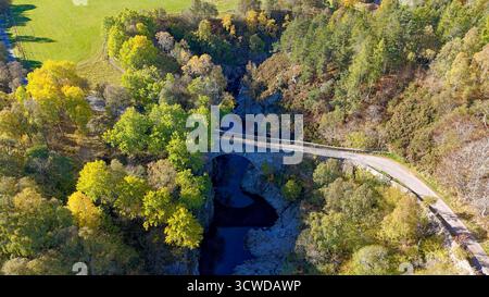 Dulsie Bridge und River Findhorn Nairn Scotland farbenfrohe Bäume die schmale Straße über die Brücke im Herbst Stockfoto