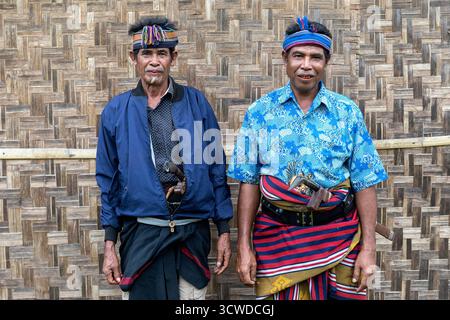 Zwei Männer posieren in typischem Outfit und traditionellen Messern, Kabeala, während der Trauerfeier auf Sumba, Indonesien Stockfoto