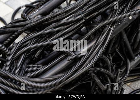 Hintergrund: Stapel von gebrauchten PVC-isolierten Elektrokabeln im Recyclingzentrum für Wertstoffe. Hochwertige photoelektrische Kabel, Hintergrund mit Blac Stockfoto