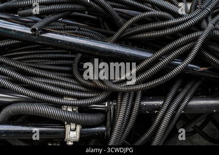 Hintergrund: Stapel von gebrauchten PVC-isolierten Elektrokabeln im Recyclingzentrum für Wertstoffe. Hochwertige photoelektrische Kabel, Hintergrund mit Blac Stockfoto