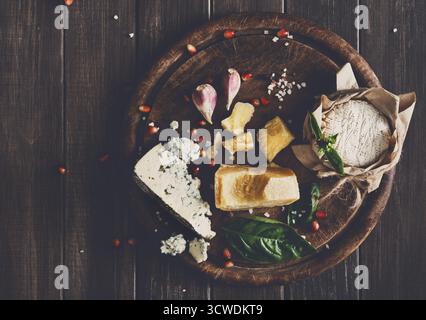 Käsedelikatessen auf rustikalem Holz, blauem roquefort, Brie und Parmesan Stockfoto