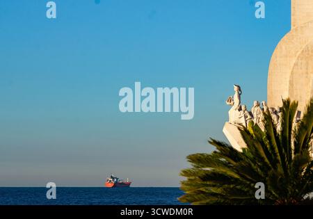 Lisboa, Portugal – monumento dos Descobrimentos em Belém com navio no horizonte atlântico ao pôr do sol Stockfoto