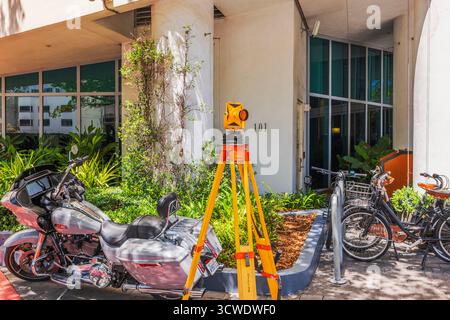 Stativ mit gelbem Prisma in der Nähe geparkter Motorräder und Fahrräder auf der Collins Avenue. Miami Beach. USA. Stockfoto