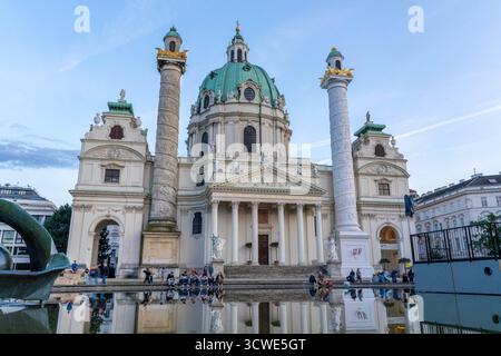 Wien Österreich - 12. September 2025: Karlskirche St. Karls in Wien Österreich mit Menschen, die um den Reflektierenden Pool sitzen Stockfoto