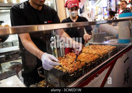 Osaka, Japan - 21. Juli 2025 : Kochen von Takoyaki Stockfoto