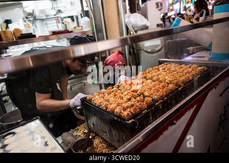 Osaka, Japan - 21. Juli 2025 : Kochen von Takoyaki Stockfoto