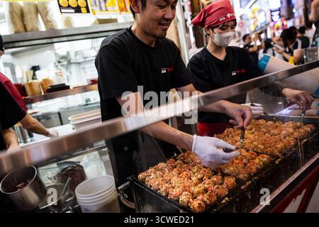 Osaka, Japan - 21. Juli 2025 : Kochen von Takoyaki Stockfoto