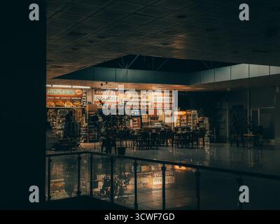 Samsun, Türkei - 2. April 2024: Geschäftiges türkisches Fast-Food-Café mit Neonschildern, Snacks und Getränken am Abend. Türkisches Café farbenfrohe Inneneinrichtung, dunkles Ambiente Stockfoto