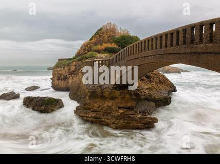 Eine bogenförmige Steinbrücke verbindet den Rocher du Basta in Biarritz, Frankreich. Stockfoto