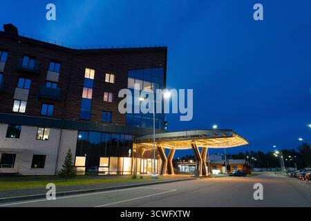 Altai, Russland - 13. Mai 2024: Abgewinkelter Blick auf die Fassade eines modernen Hotelgebäudes mit großen Fenstern und einem hell beleuchteten Eingang mit dekorativem Dekor Stockfoto