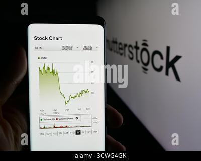 Deutschland. Oktober 2025. In dieser Fotoabbildung hält eine Person ein Smartphone mit der Webseite des Aktienfotografen Shutterstock Inc. Auf dem Bildschirm vor dem Logo. Quelle: SOPA Images Limited/Alamy Live News Stockfoto