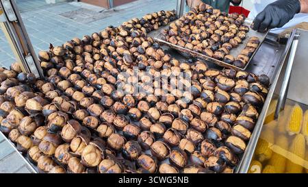 Geröstete Kastanien stapelten sich im Herbst auf dem Markt im Freien Stockfoto